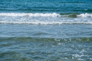Denizde kıyıya inişli çıkışlı dalgalar.