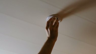 Mens el bir ampul tavandaki sıkma. Sonra lamba yanar ve aydınlatır. Closeup 4k