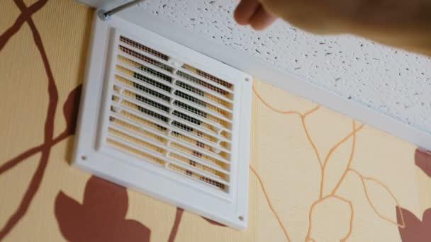 Manos masculinas Desenrosque los tornillos con un destornillador en las rejillas de ventilación de la casa. Primer plano 4K . — Vídeos de Stock