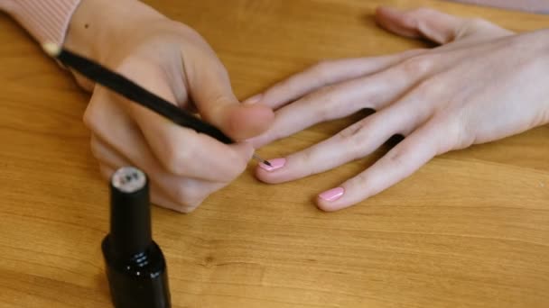 Una mujer haciéndose una manicura en casa sobre la mesa. Primer plano 4K — Vídeo de stock