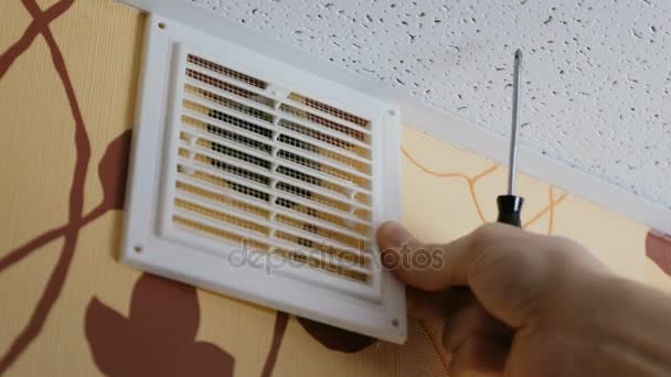 Macho apretando a mano los tornillos con un destornillador en las rejillas de ventilación de la casa. Primer plano 4K . — Vídeo de stock
