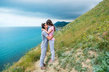 Erkek ve kadın dağda sarılma. Deniz Manzaralı.