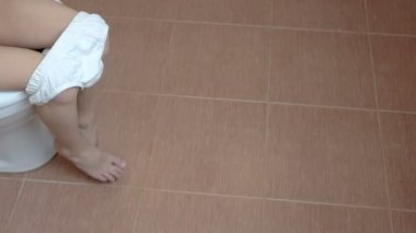 Çocuk tuvalet banyo ve bacaklarını sallanan oturur. 4 k. ayak portre