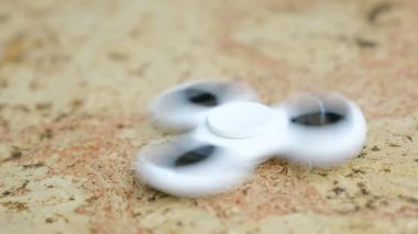 Ahşap bir masaya dönmeye beyaz el spinner. 4k
