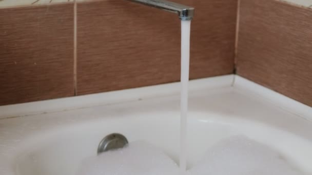 Flusso di acqua che si riversa nel bagno con schiuma. Chiudete. Movimento della fotocamera dall'alto verso il basso . — Video Stock