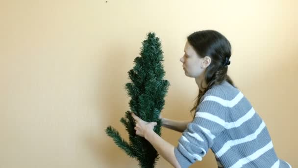 La mujer conecta la rama a la parte superior del árbol artificial. Elimina la parte superior del árbol . — Vídeo de stock