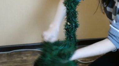 Kadın yapay Noel ağacının gövde temizler. Noel'den sonra düzenli