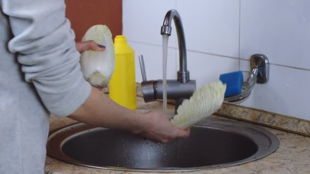 Unrecognizable woman washes chinese cabbage in the kitchen. Side view. — Stock Video
