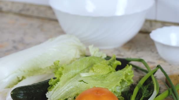 Warzywa: kapusta pekińska, ogórek, pomidor, koperek, zielona cebula na stole w kuchni. Z bliska. — Wideo stockowe