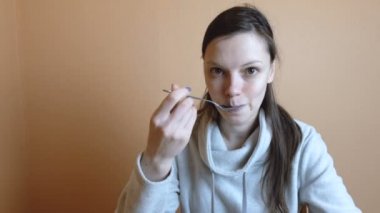 Yorgun kadın bruenette gri ceketli işten sonra sebze salatası yiyor.