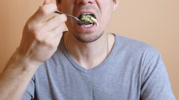 Homem irreconhecível em camiseta cinza come salada de legumes. Mãos e boca de perto . — Vídeo de Stock