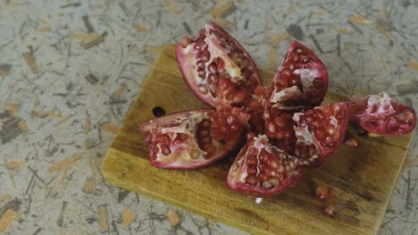 Cut the pomegranate on a cutting Board. Camera movement from left to right. — Stock Video