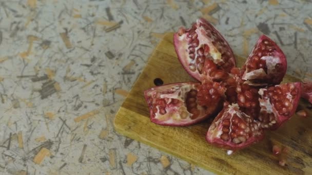 Cut the pomegranate on a cutting Board. Camera movement from left to right in center. — Stock Video