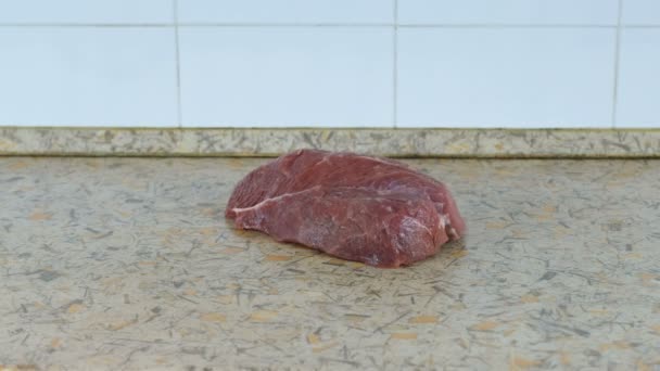 Dwa duże soczyste kawałki mięsa rzucić się na stole w kuchni. Widok z boku. — Wideo stockowe