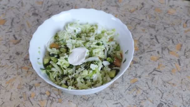 Plantaardige groene salade in een bord op de keukentafel. Camerabeweging van rechts naar links. — Stockvideo