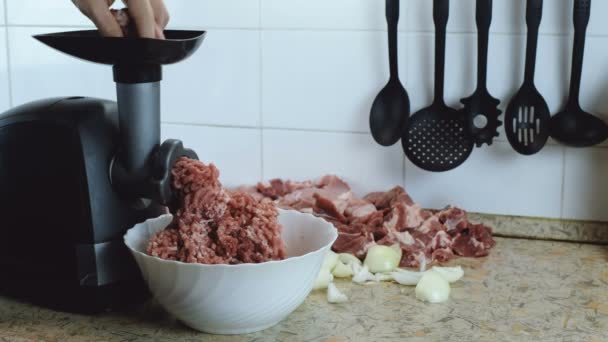Zbliżenie męskie ręce, wprowadzanie mięsa wołowego i wieprzowego mięsa i cebuli przez maszynę mielącą w kuchni. Side wiev. — Wideo stockowe
