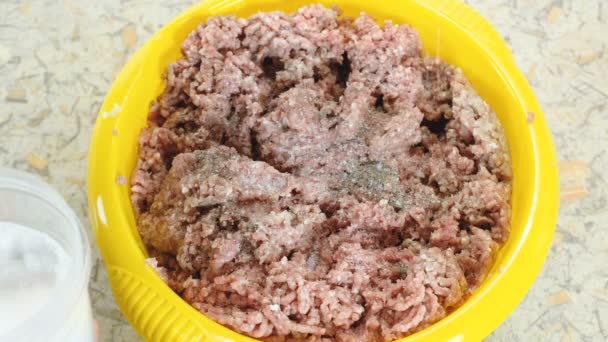 Makro mans dłoni soli i pieprzu mielonego mięsa w Kotlinie żółty w domowej kuchni. Widok z góry. — Wideo stockowe