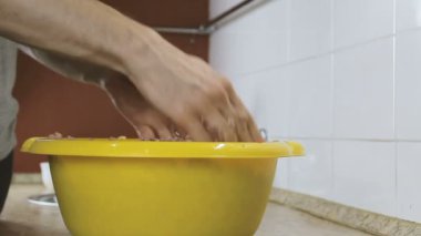 Yakın çekim eller mix kıyılmış et ile tuz ve biber sarı havzasında mans. Yan görünüm.