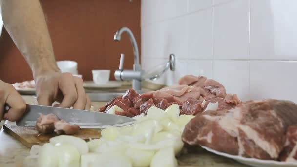 Mãos de mulher de close-up cortando um enorme pedaço suculento de porco em pedaços grandes para churrasco. Vista lateral . — Vídeo de Stock