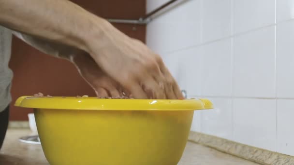 Primer plano mans manos mezclar carne picada con sal y pimienta en la cuenca amarilla. Vista lateral . — Vídeos de Stock