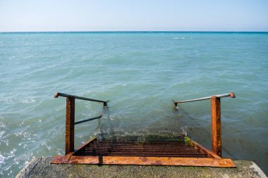 Paslı metal merdiven iskeleden denize iner. Üstten Görünüm.