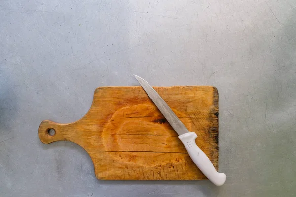 Steel knife on a cutting board on metal background. — Stock Photo, Image