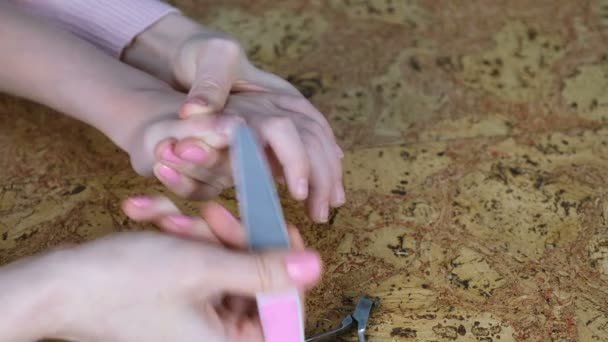 Moeder wil haar zoon door Clippers op hout achtergrondkleur en bestand die hem nagels snijden nijnagel. Close-up handen — Stockvideo