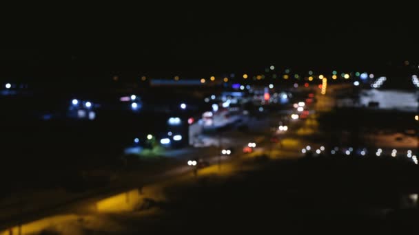 Vista borrosa de la ciudad y la carretera desde una altura. Tráfico de autos borrosos en la ciudad. Noche. . — Vídeo de stock