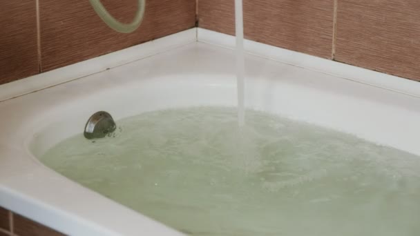 Vatten hälls i badkaret. Full bad. Närbild. En stark ström av vatten. — Stockvideo