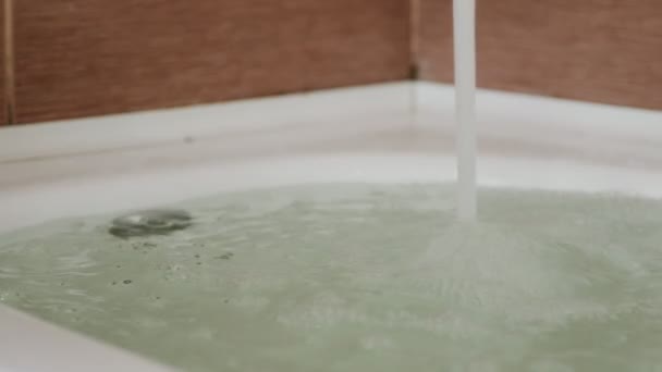 Starker Wasserstrahl ergießt sich in die Wanne. Badewanne läuft über. Nahaufnahme. — Stockvideo