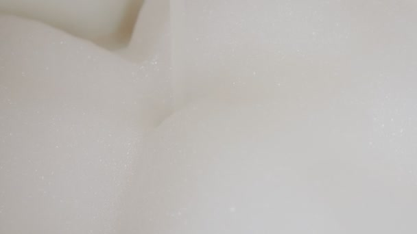 Vízsugár ömlött be a hab a fürdőben. Közelről. Kamera a hab. — Stock videók