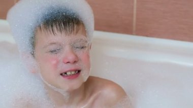 Çocuk 6-7 yıl gözleri kapalı bir köpük banyosu dalış. Yankiler geri.