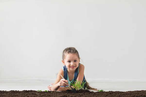 Chica acostada en el suelo y se sienta abajo de la planta en el suelo — Foto de Stock