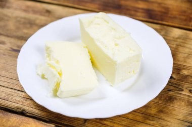 Yakın çekim taze çiftlik ezmesi ahşap arka plan üzerinde beyaz bir tabakta parçası. Taze tarım ürünleri.