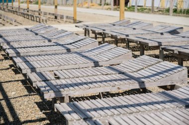 Yakın çekim ahşap şezlong üzerinde seashore tarafından çakıllı bir halk plajı. Yan görünüm.