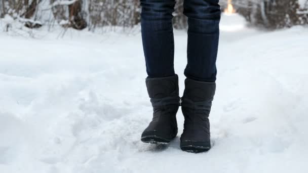 Крупный план замерзших ног женщины в сапогах в снегу, топающей от холода . — стоковое видео
