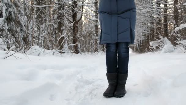 Close-up das pernas congeladas de uma mulher em botas na neve tremendo do frio . — Vídeo de Stock