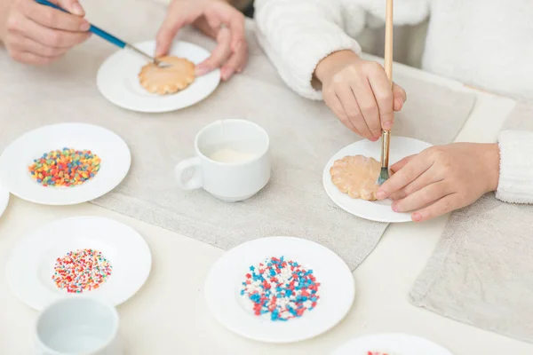Mamma och hennes dotter baka ihop och dekorera cookies — Stockfoto