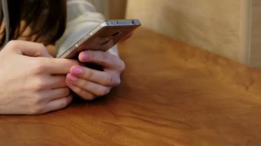 Yakın çekim kadının telefonunu kafede oturan çalışma parlak gömlekli eller.