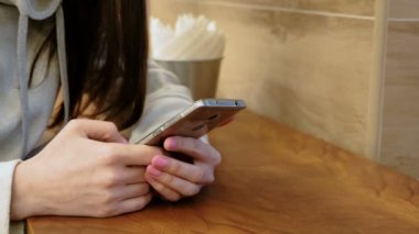 Kafede otururken ona cep telefonu mesajlaşma parlak gömlekli yakın çekim womans eller.