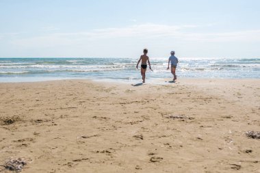 Kumlu sahilde yalınayak denizin dalgaları ile için güneşli bir günde tanınmaz 6y eski çocuklar.
