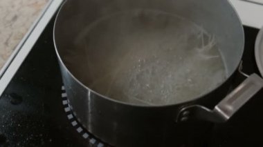 Pirinç spagetti bir tencerede kaynar su ocakta pişiyor. Yan görünüm.