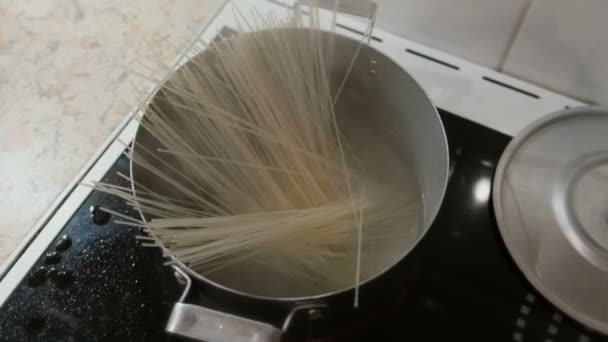 Spaghetti van de rijst wordt gekookt in een pot van kokend water op het fornuis. Bovenaanzicht. — Stockvideo