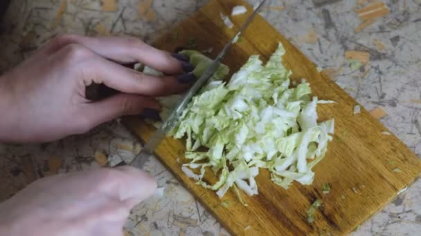 Unrecognizable woman cut chinese cabbage on cutting board in kitchen table. Hands close up. View top — Stock Video