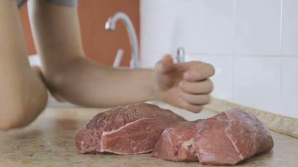 Man biter av en bit av rå nötkött och tuggar det. Eskimo äta okokt nötkött kött — Stockvideo