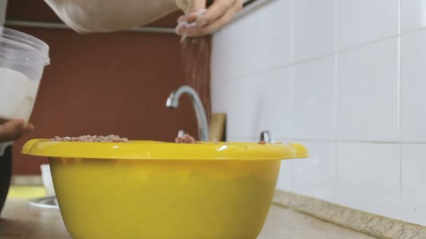 Primer plano mans mano sal carne picada en la cuenca amarilla en casa cocina — Vídeos de Stock