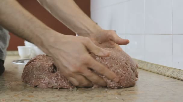 Mãos de homem de close-up misturam carne picada na mesa. Vista lateral . — Vídeo de Stock