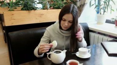 Kadın esmer çaydanlık açar, o burnunu çekmek ve bir su ısıtıcısı çay bir fincan içine dökülen.
