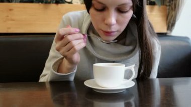kadın sıcak çay bir kaşıkla bardaktan içer. El ve yüz kadar kapatın.