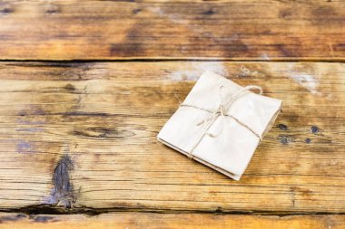 Hediye kraft Kağıt ahşap arka plan üzerinde sarılı..